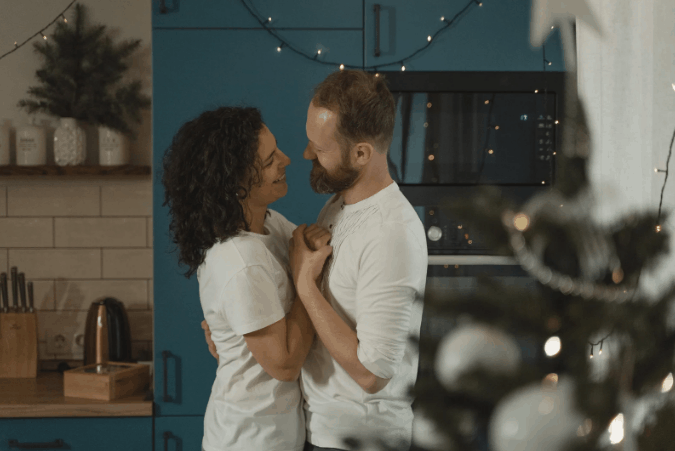 A couple dancing beside the Christmas tree